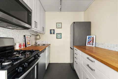 a kitchen with stainless steel appliances granite countertop a refrigerator and a stove