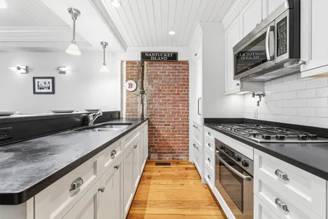 a large kitchen with granite countertop a stove and a sink