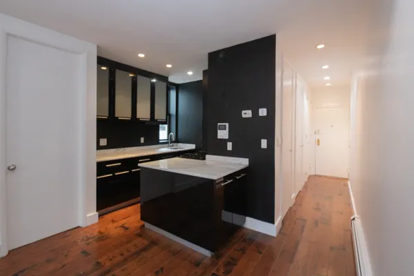 a kitchen with a sink a refrigerator and chairs