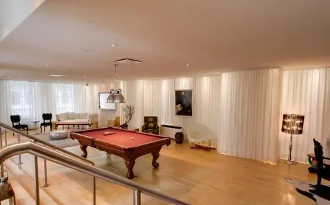 a living room with furniture pool table and a window