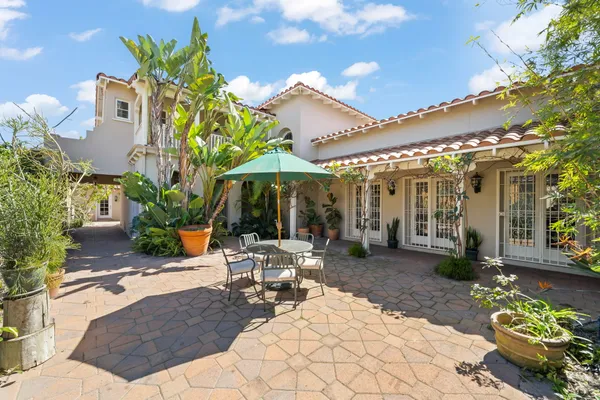 a view of a patio with couches and table and chairs and potted plants