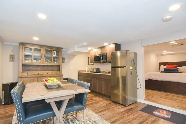a kitchen with stainless steel appliances refrigerator dining table and chairs