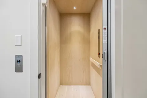 a view of an empty room with window and cabinet