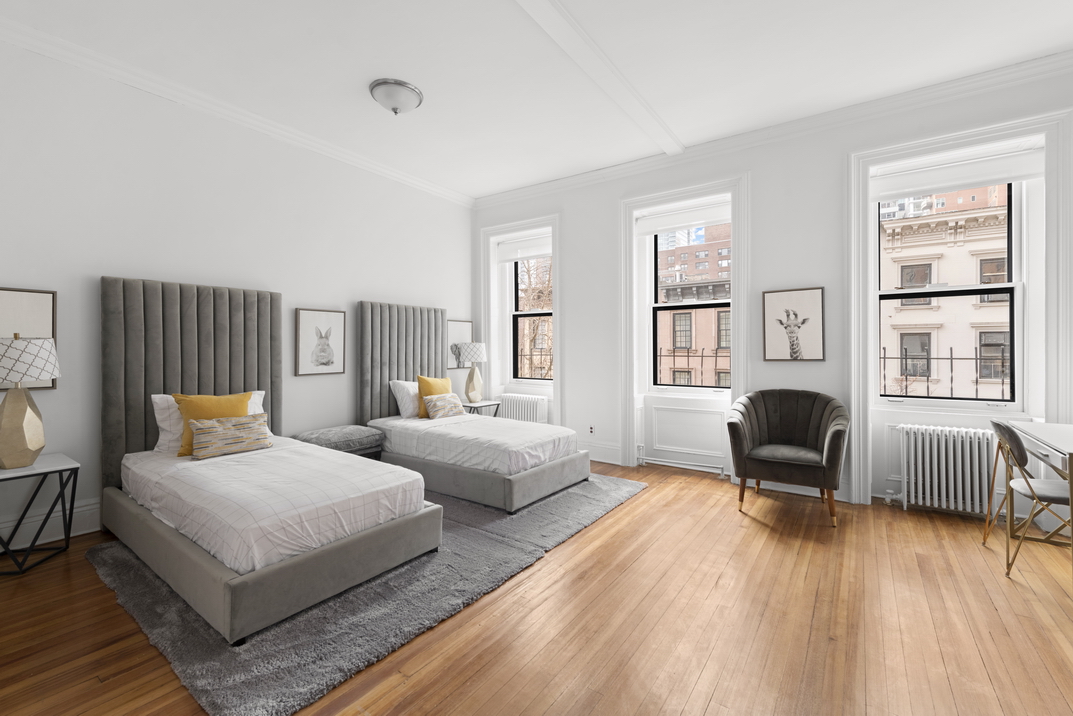 209 East 61st Street Manhattan, NY 10065 - Photo 15 of 27 a bedroom with a bed and wooden floor