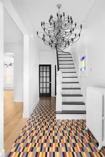a view of a hallway with wooden floor and a chandelier