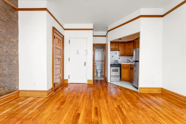 a view of a kitchen with wooden floor and a refrigerator