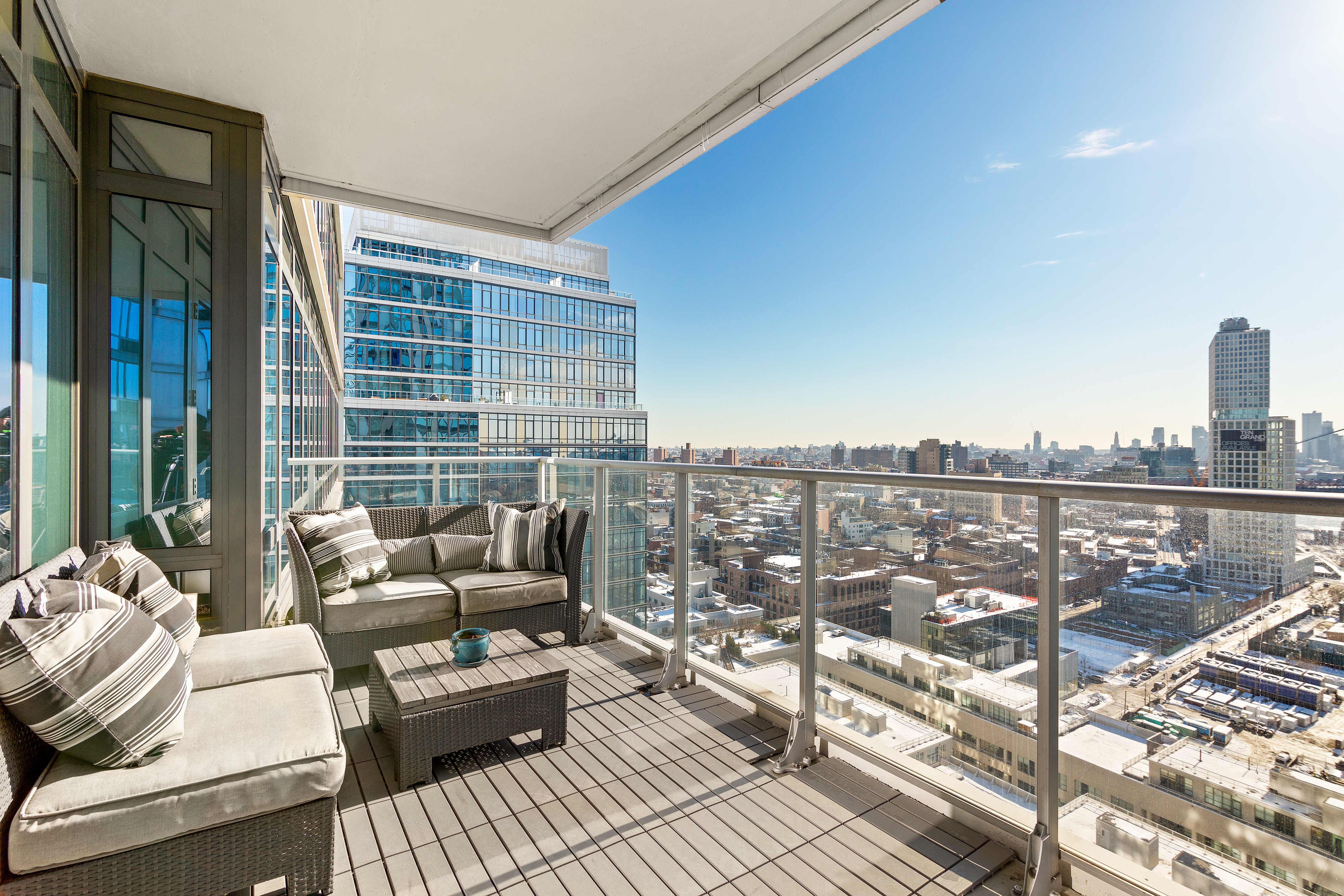 2 Northside Piers, Unit 17A Brooklyn, NY 11249 - Photo 6 of 21 a balcony with couch and a potted plant on the wall