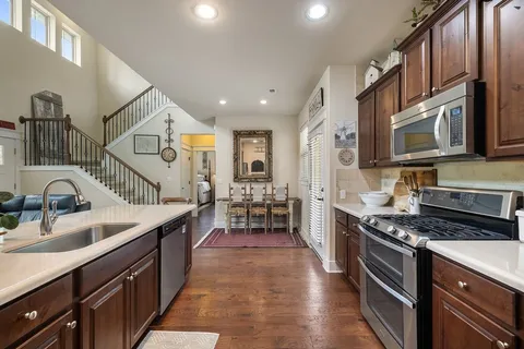 a kitchen with stainless steel appliances granite countertop a sink stove and cabinets