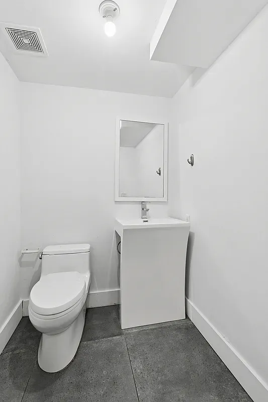 a bathroom with a sink toilet and mirror