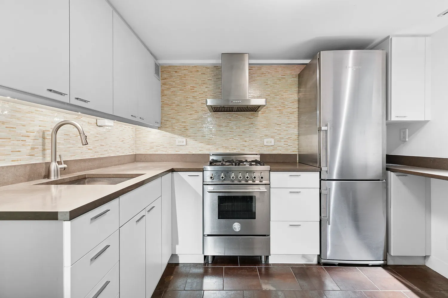 a kitchen with stainless steel appliances a refrigerator sink and cabinets