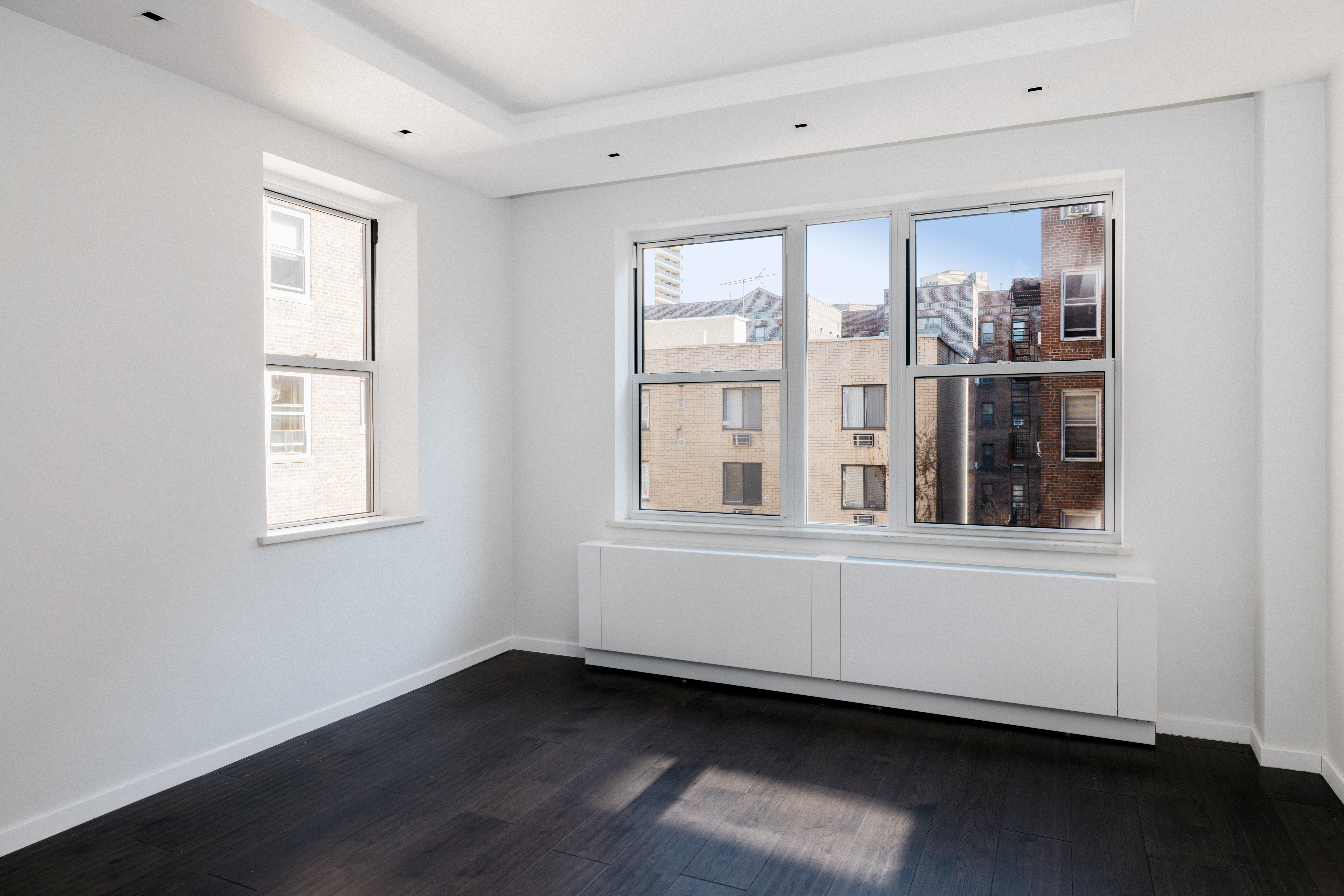 71-36 110th Street, Unit 4C Queens, NY 11375 - Photo 5 of 14 a view of an empty room with wooden floor and a window