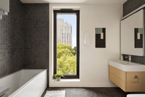 a bathroom with a tub sink and mirror