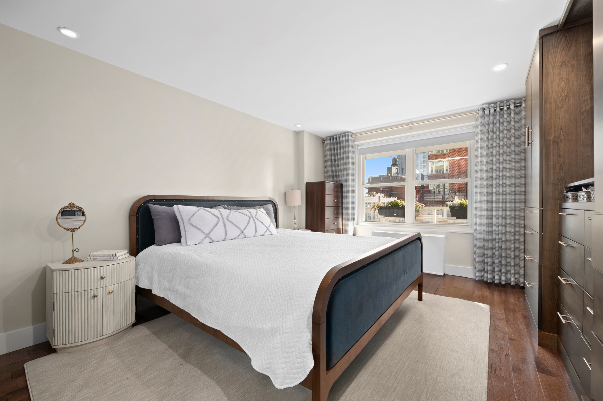 370 East 76th Street, Unit B702 Manhattan, NY 10021 - Photo 6 of 9 a bedroom with a large bed and a flat tv screen on dresser