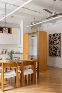 a kitchen with stainless steel appliances kitchen island granite countertop a table chairs and a refrigerator