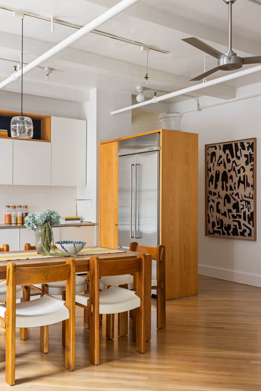 130 West 17th Street, Unit 5S Manhattan, NY 10011 - Photo 8 of 17 a kitchen with stainless steel appliances kitchen island granite countertop a table chairs and a refrigerator