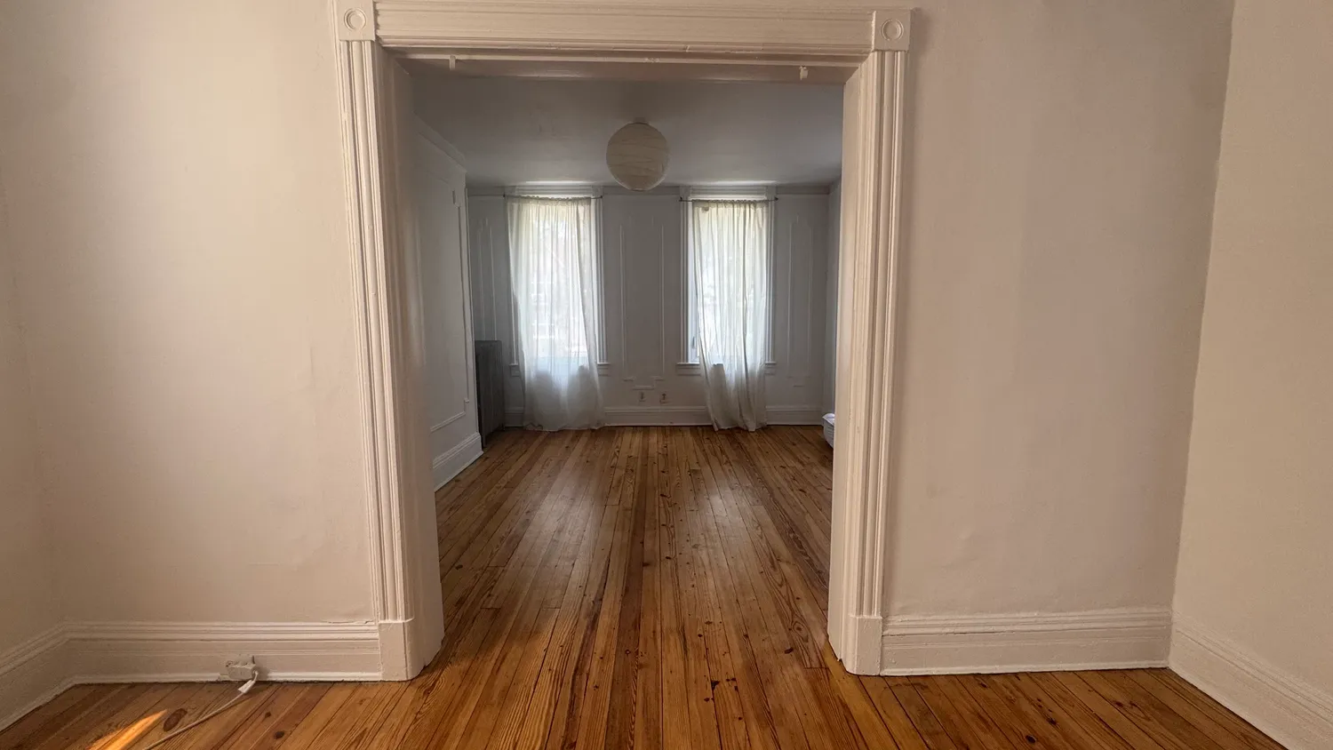 a view of a room with wooden floor and a window