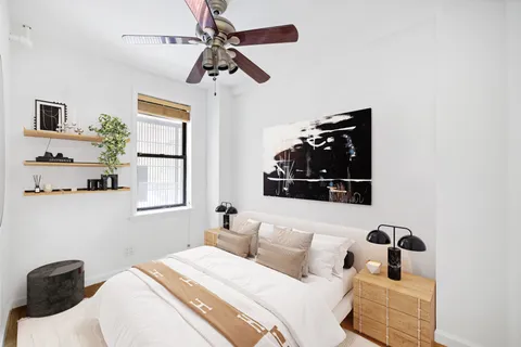 a bedroom with a bed and wooden floor