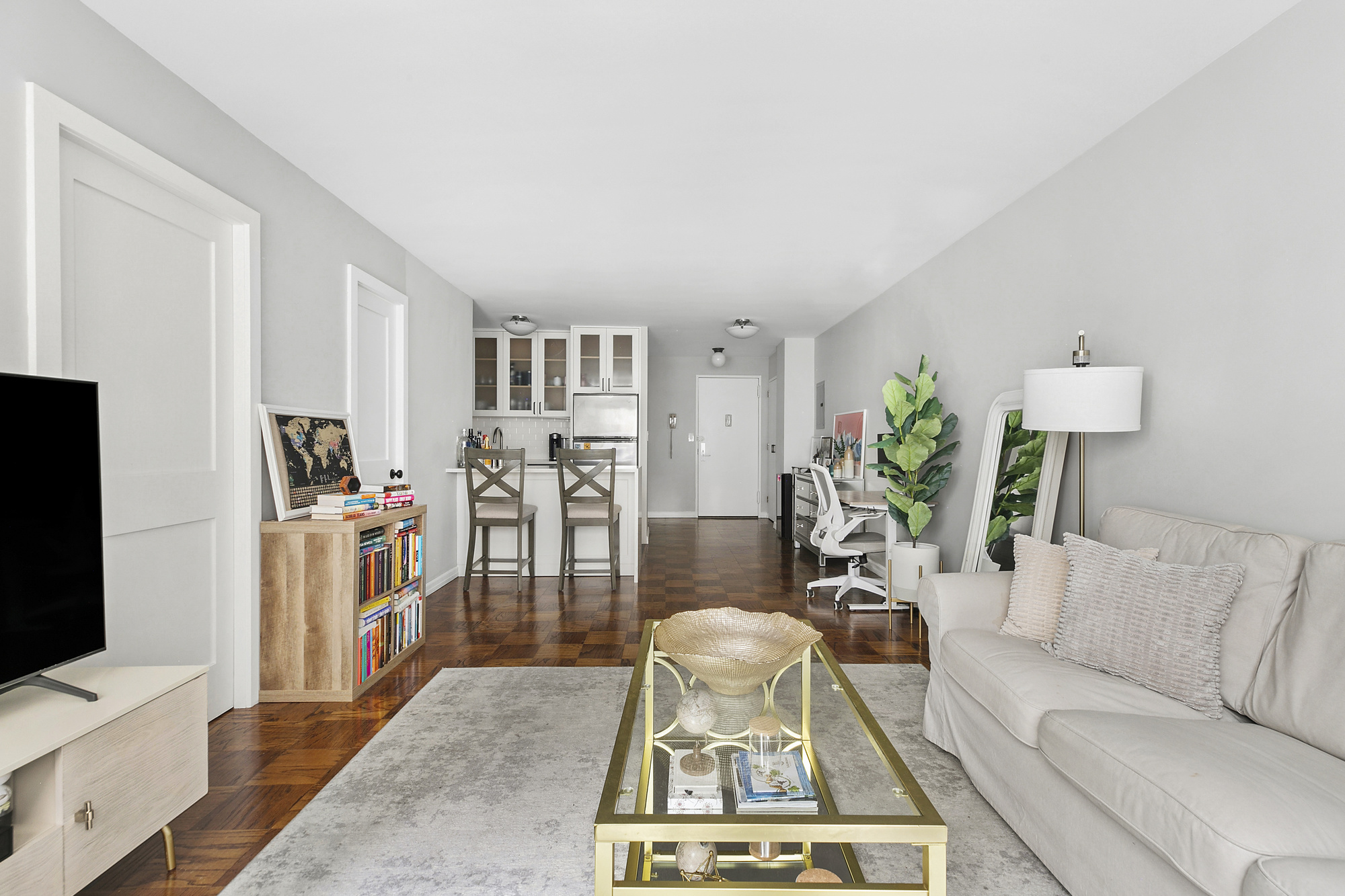 16 West 16th Street, Unit 3RN Manhattan, NY 10011 - Photo 2 of 9 a living room with furniture a flat screen tv and a table