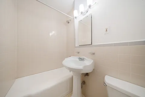 a bathroom with a sink a toilet and mirror