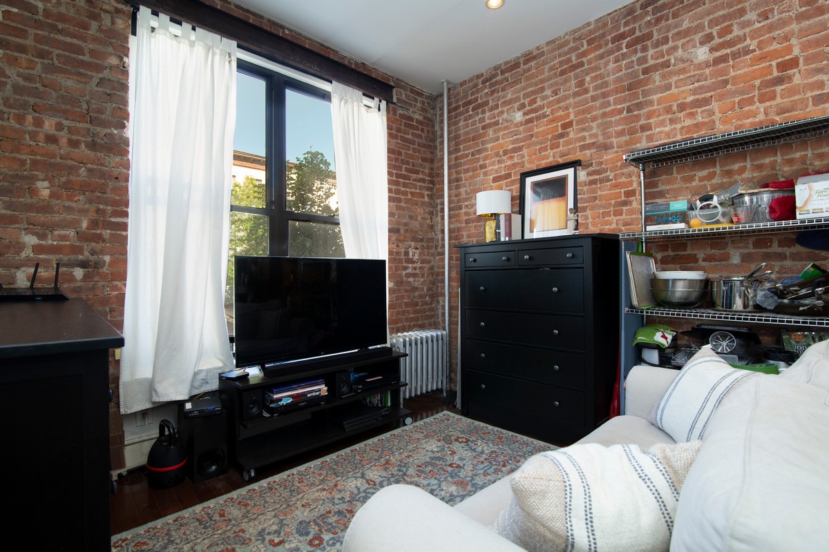 445 Rogers Avenue, Unit 1LF Brooklyn, NY 11225 - Photo 2 of 6 a bedroom with a bed flat screen tv and a window