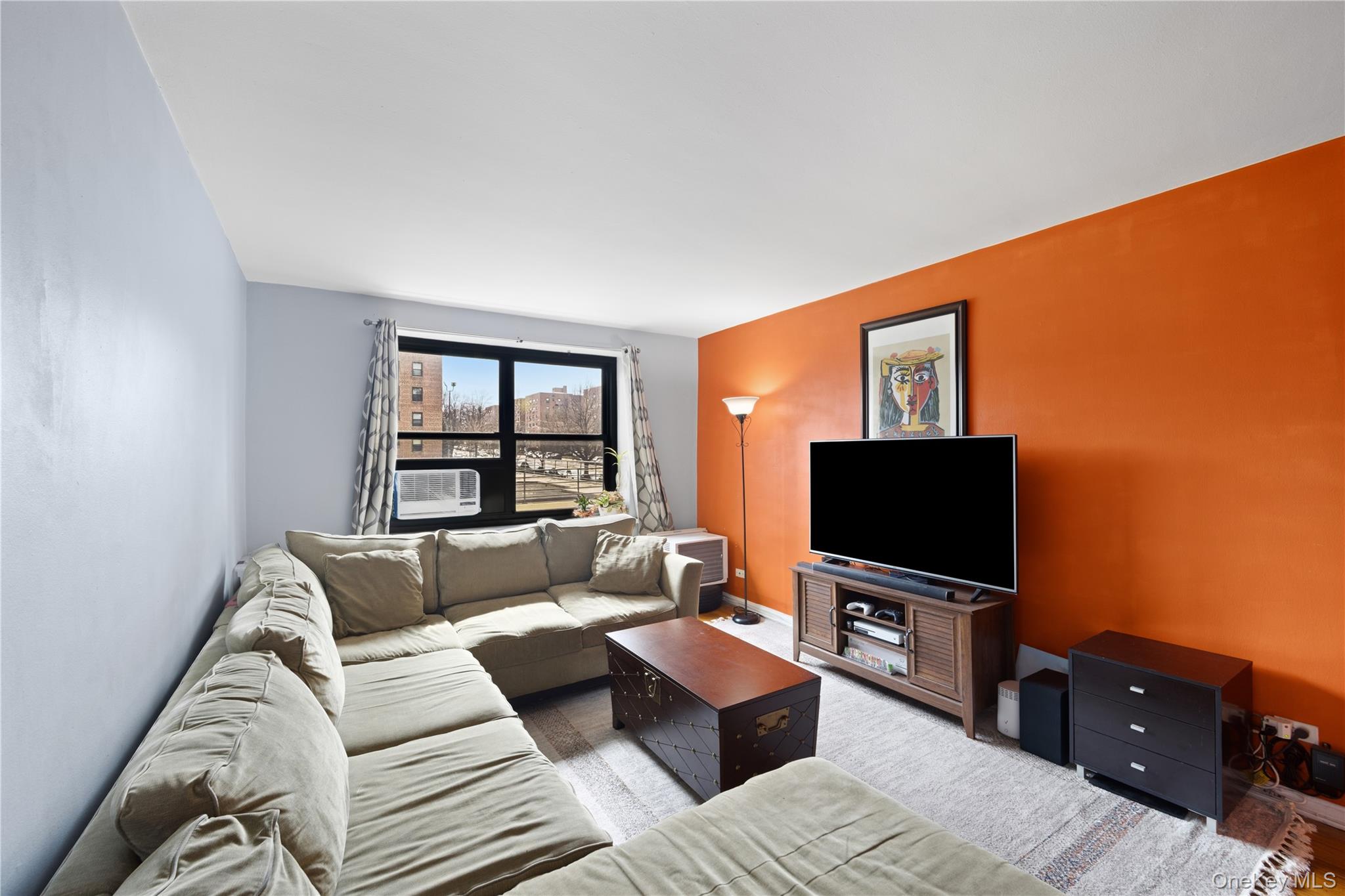 73-11 Bell Boulevard, Unit 2C Queens, NY 11364 - Photo 7 of 16 a living room with furniture and a flat screen tv