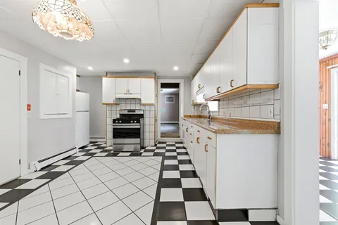 a kitchen with a checkered floor and white cabinets