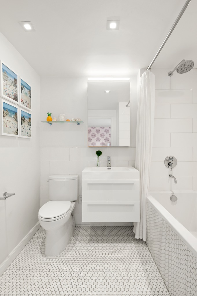 520 West 23rd Street, Unit 8A Manhattan, NY 10011 - Photo 7 of 16 a bathroom with a bathtub shower sink vanity and toilet