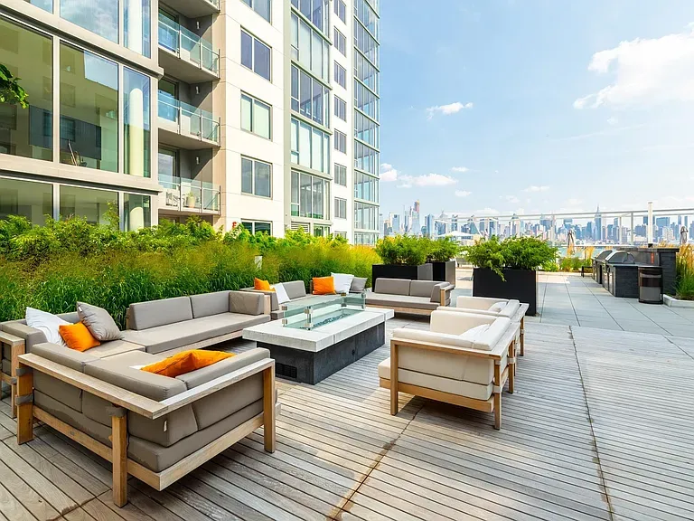 a view of a roof deck with couches and potted plants