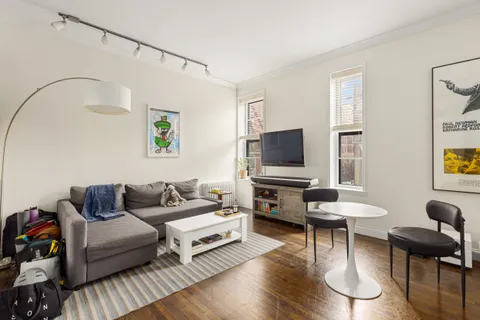 a living room with furniture a flat screen tv and a window