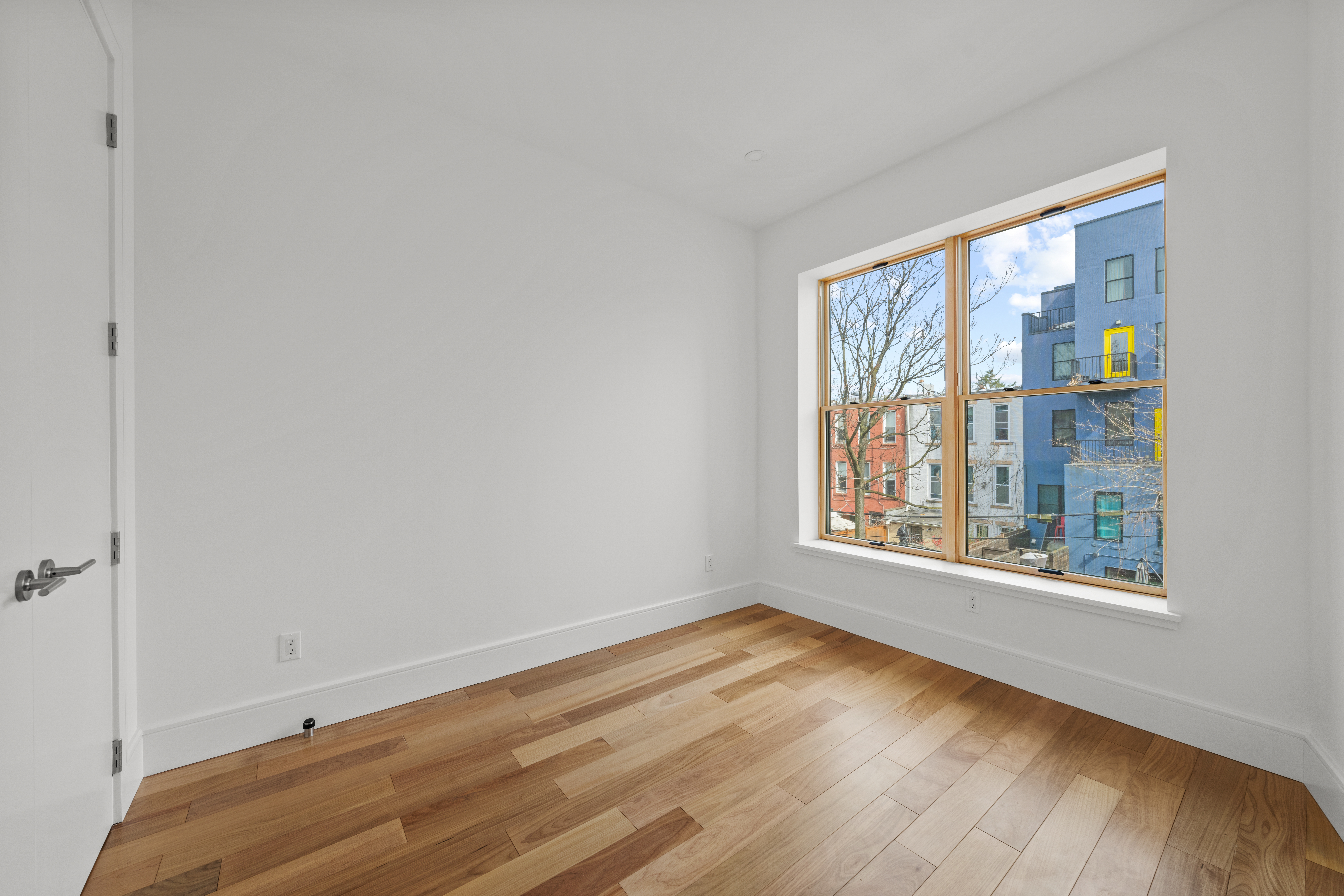82 Cooper Street, Unit 2B Brooklyn, NY 11207 - Photo 10 of 17 a view of an empty room with wooden floor and a window