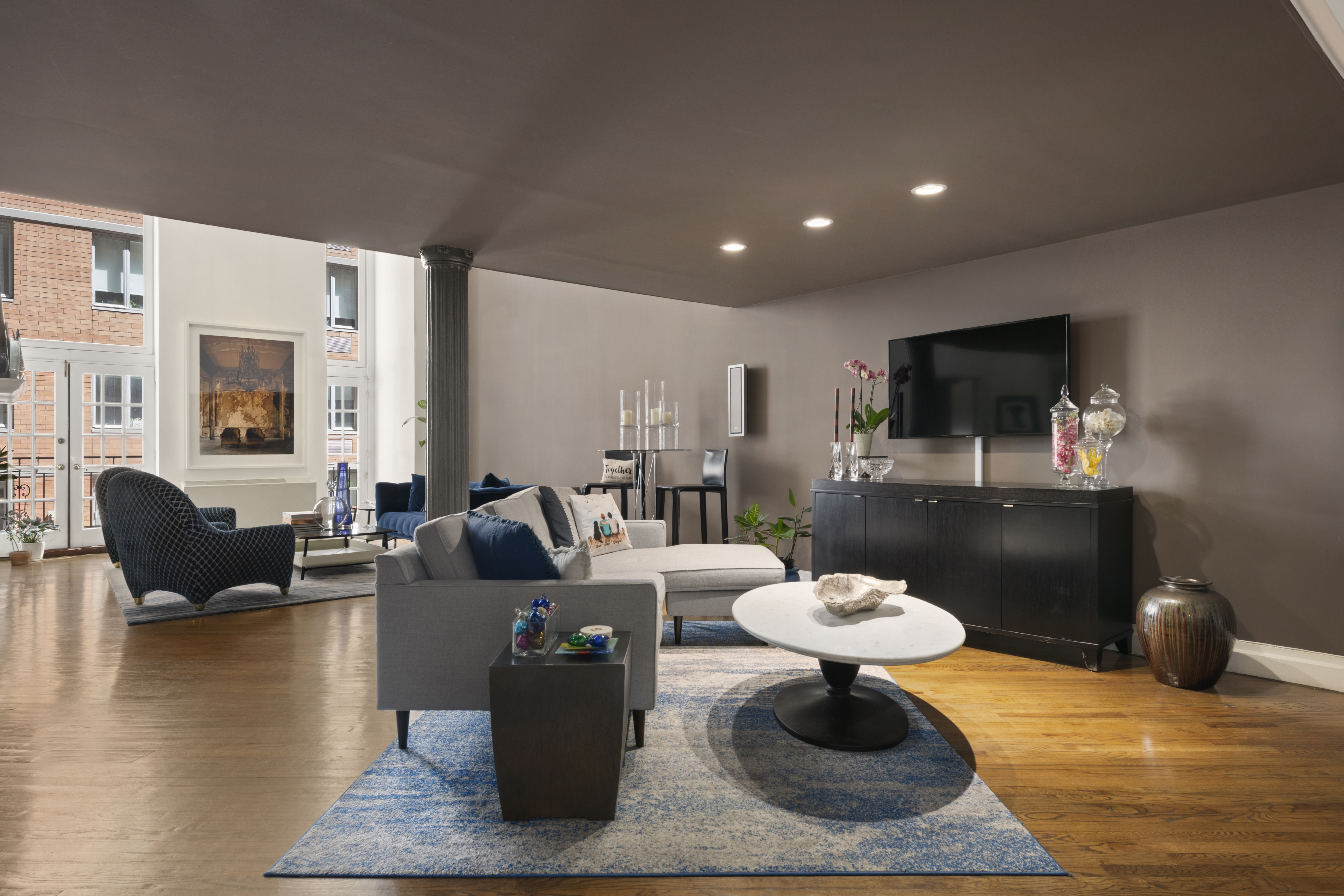 121 West 20th Street, Unit 2D Manhattan, NY 10011 - Photo 3 of 12 a living room with furniture a flat screen tv and a fireplace