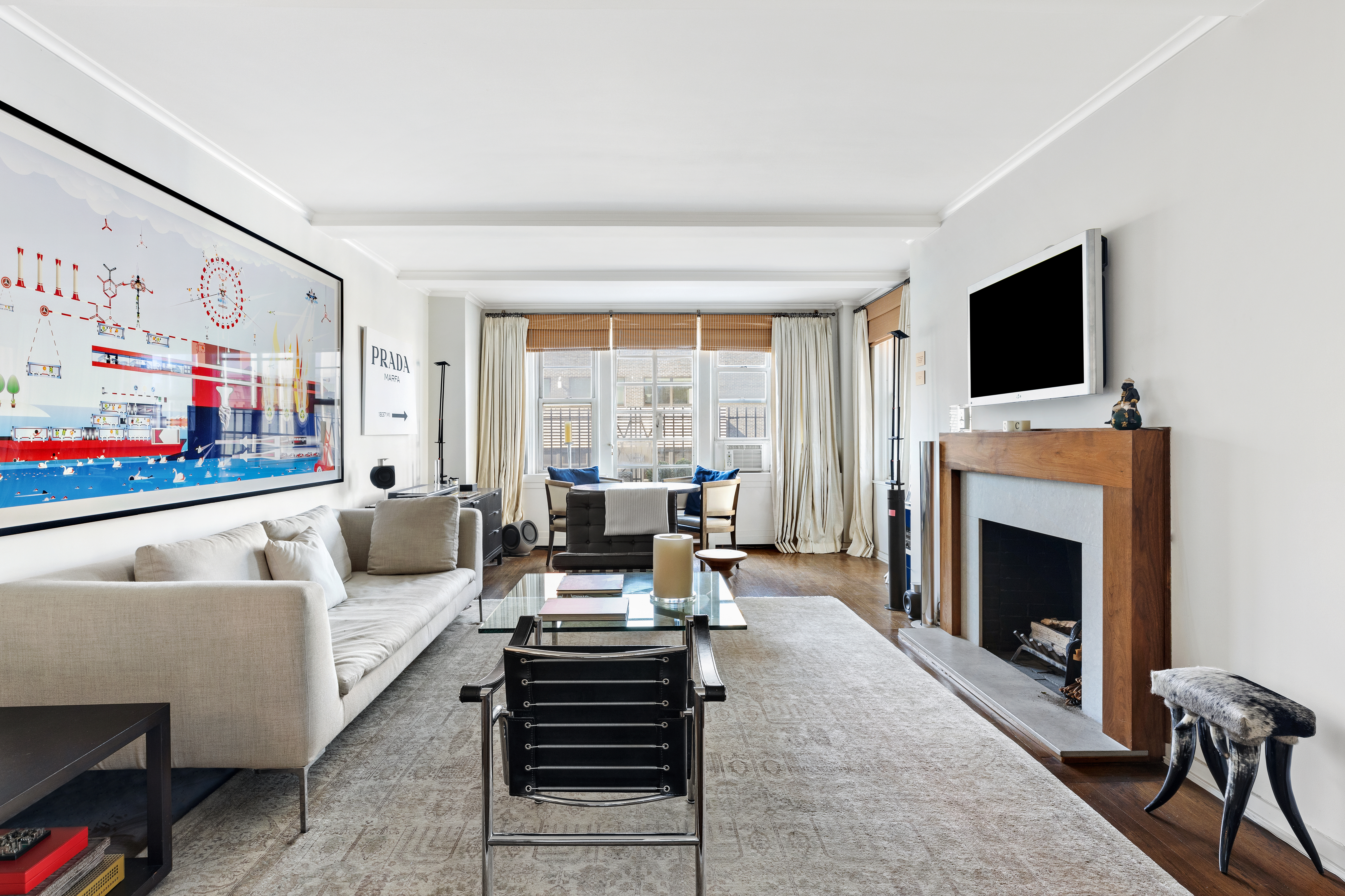 59 West 12th Street, Unit 11C Manhattan, NY 10011 - Photo 3 of 10 a living room with furniture a flat screen tv and a fireplace