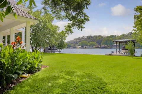 a view of a swimming pool with lawn chairs and plants