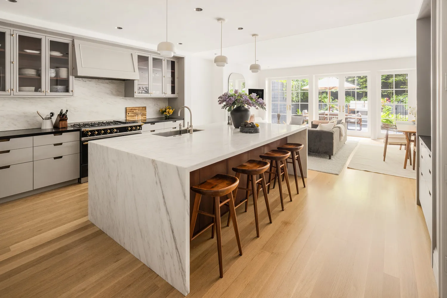 a kitchen with stainless steel appliances granite countertop a stove a sink dishwasher and a refrigerator with wooden floor