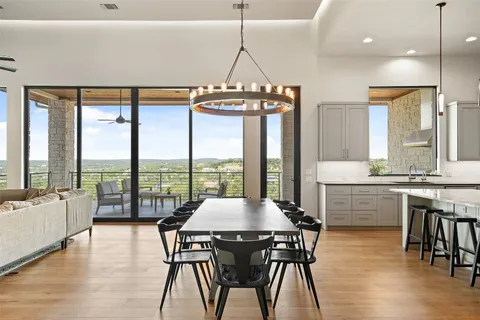 a view of a dining room with furniture large windows and wooden floor