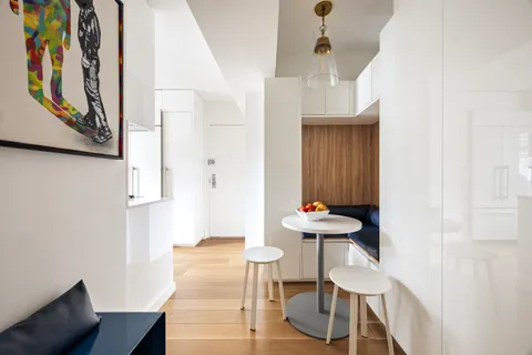 a view of a hallway with furniture and wooden floor