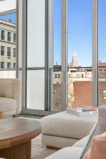 a living room with a bed furniture and next to a window