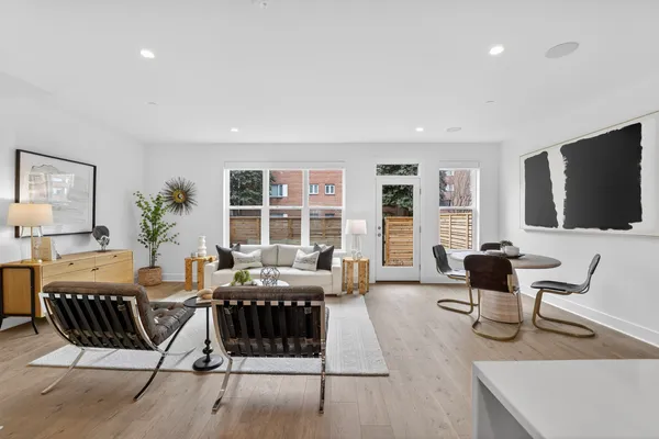 a living room with furniture a flat screen tv and large window