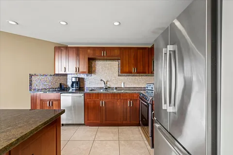 a kitchen with stainless steel appliances granite countertop a sink stove and microwave