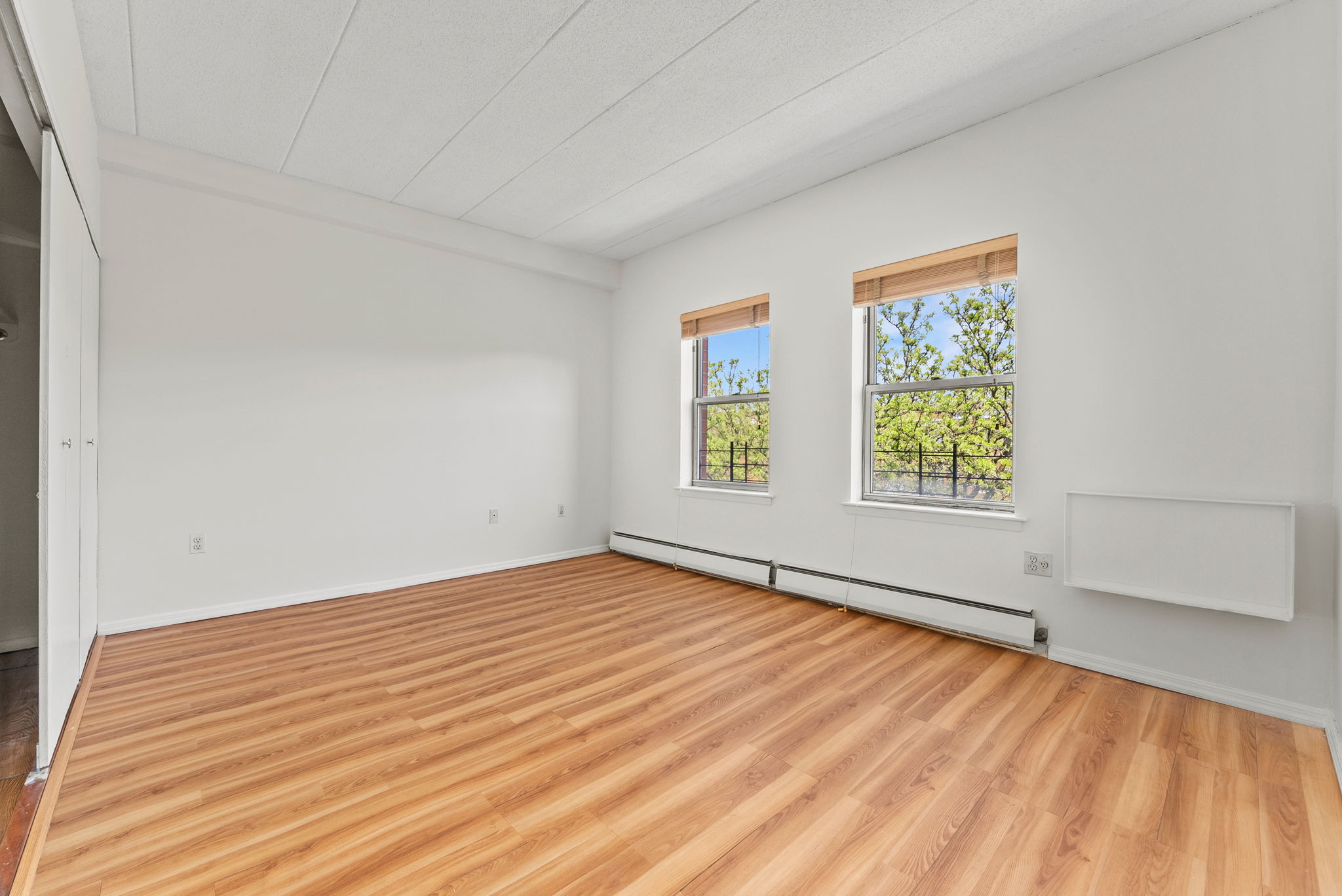 2573 Frederick Douglass Boulevard, Unit D Manhattan, NY 10030 - Photo 8 of 13 an empty room with wooden floor and windows