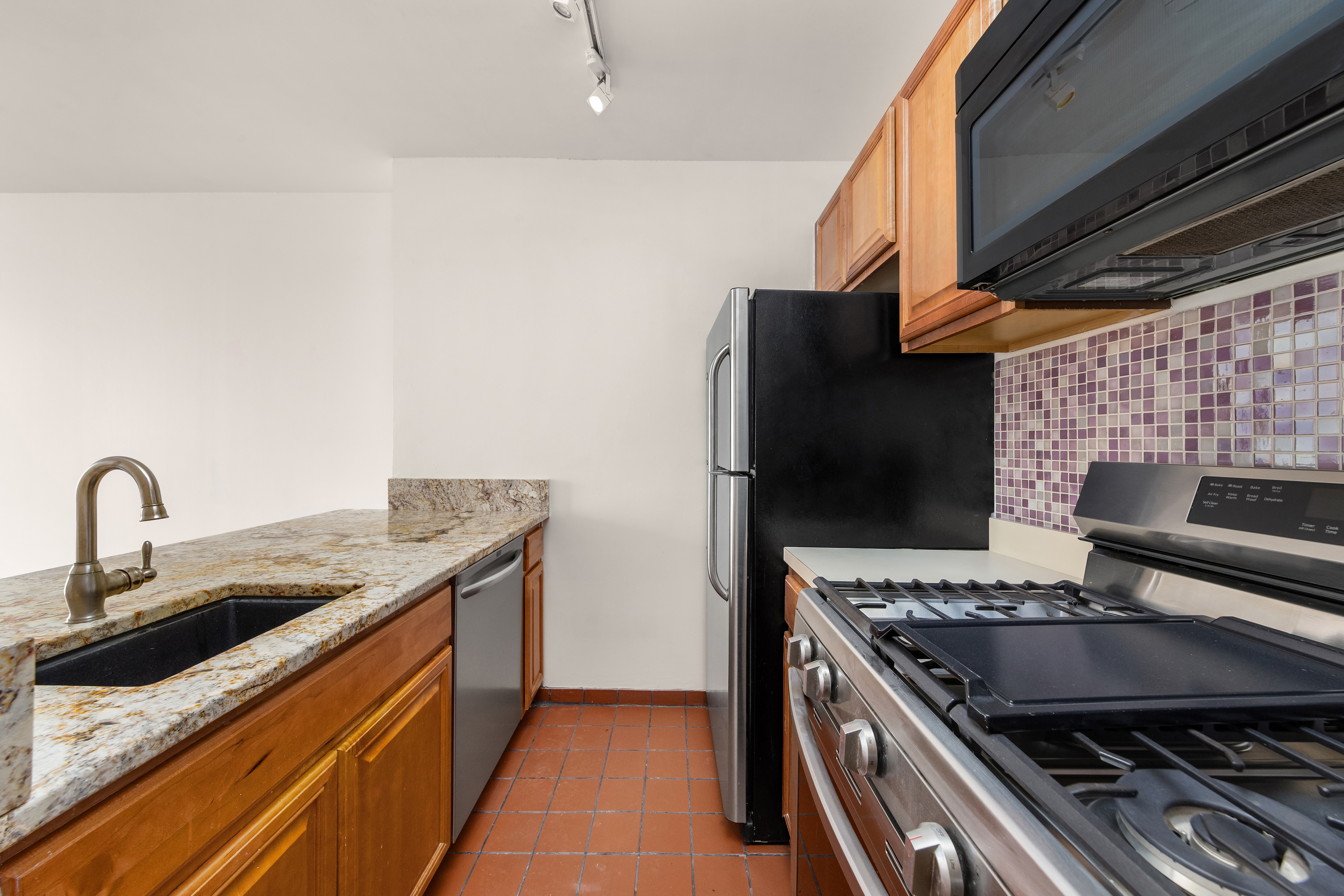 5 East 22nd Street, Unit 3N Manhattan, NY 10010 - Photo 3 of 9 a kitchen with stainless steel appliances granite countertop a stove and a sink