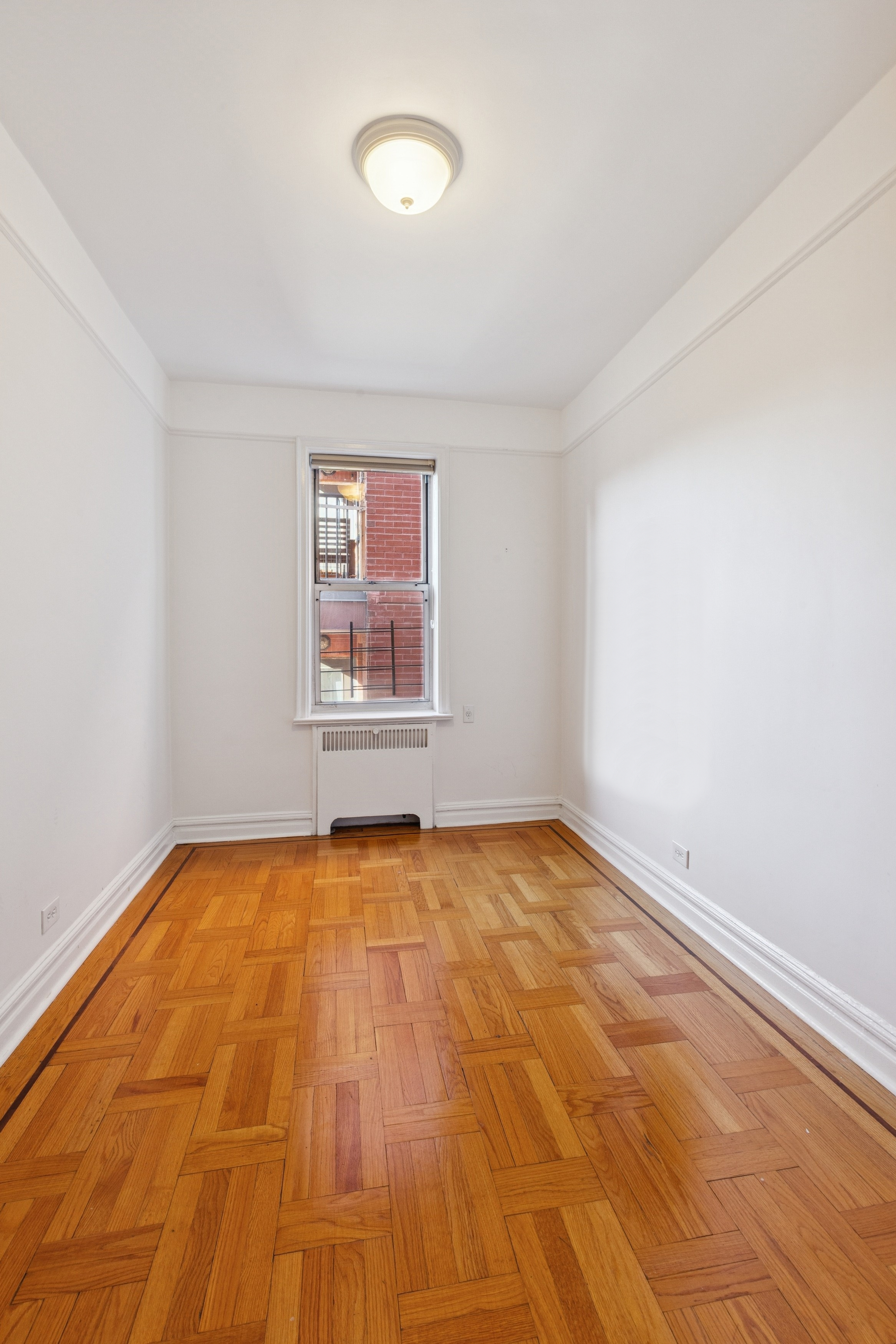 680 West 204th Street, Unit 5E Manhattan, NY 10034 - Photo 9 of 23 a view of a room with wooden floor and white walls