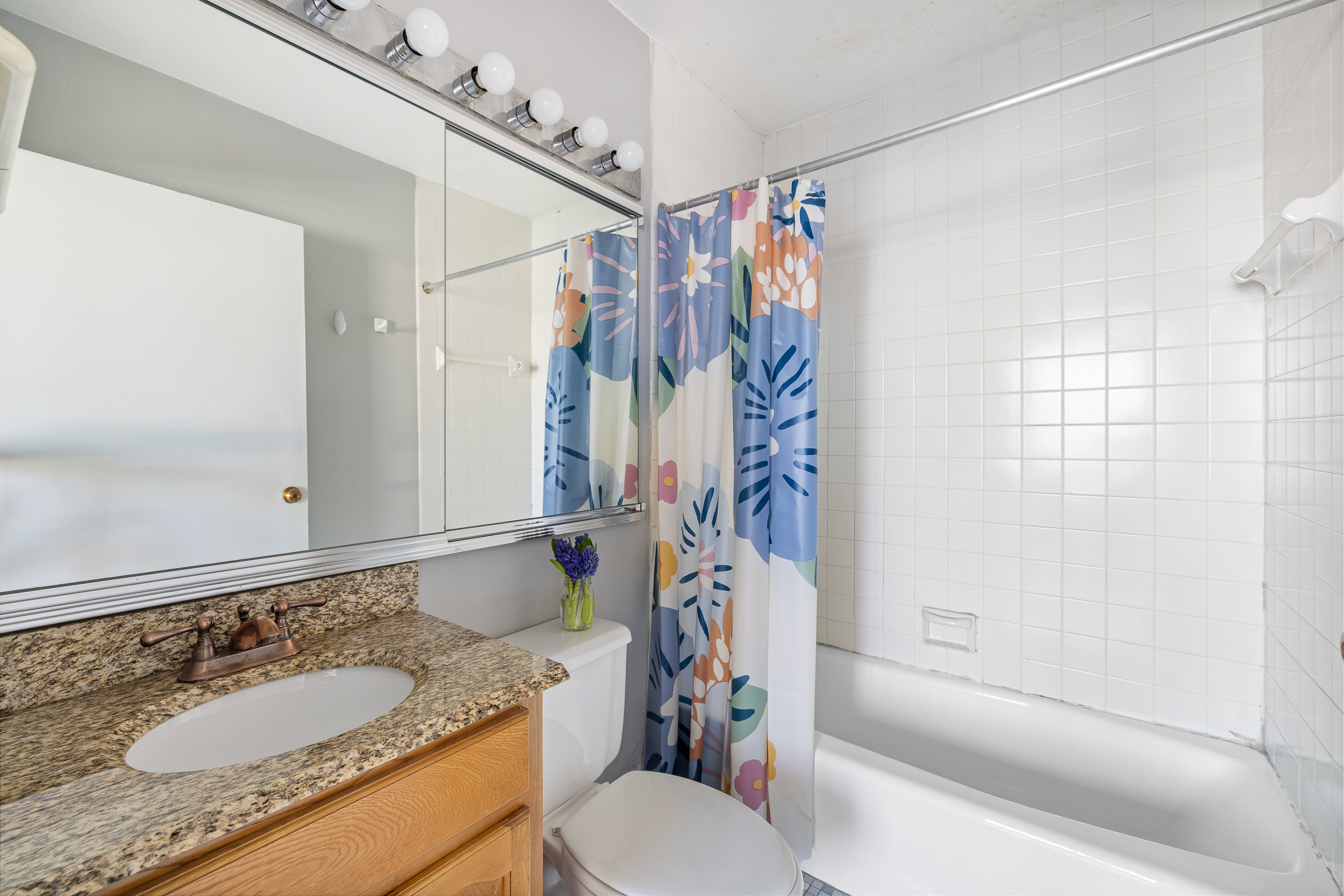 61 West 62nd Street, Unit 19C Manhattan, NY 10023 - Photo 5 of 7 a bathroom with a granite countertop sink toilet and shower