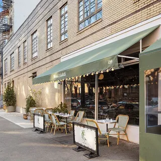 a view of a building with a large window and sitting area