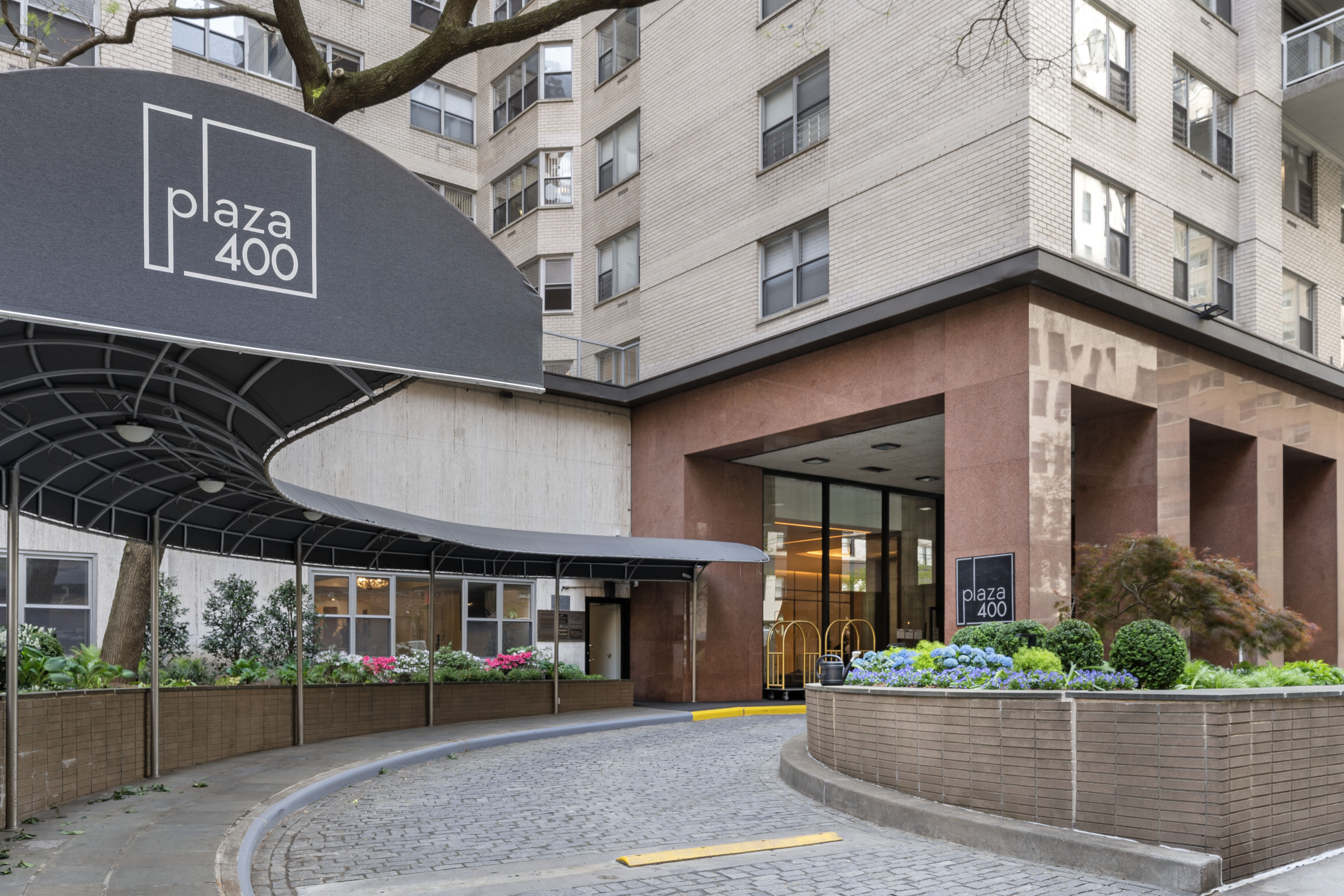 400 East 56th Street, Unit 38S Manhattan, NY 10022 - Photo 13 of 16 a front view of a building with a garden