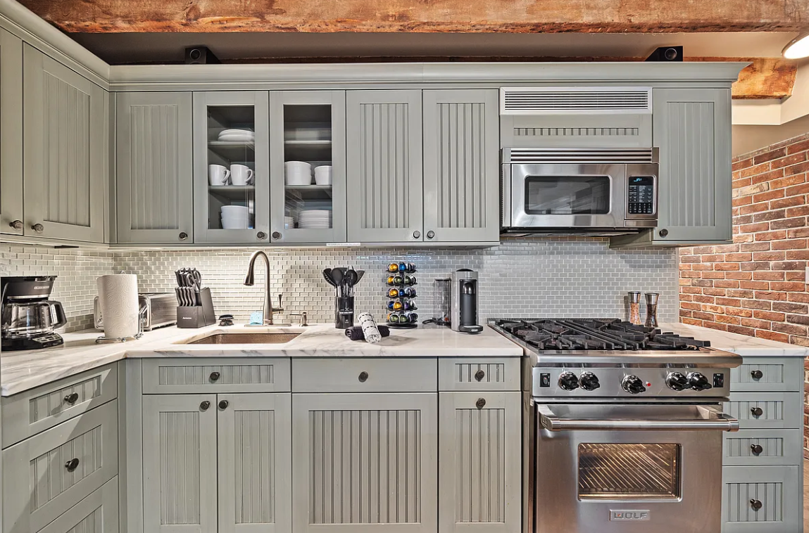58 Downing Street Manhattan, NY 10014 - Photo 11 of 27 a kitchen with granite countertop a stove sink and cabinets