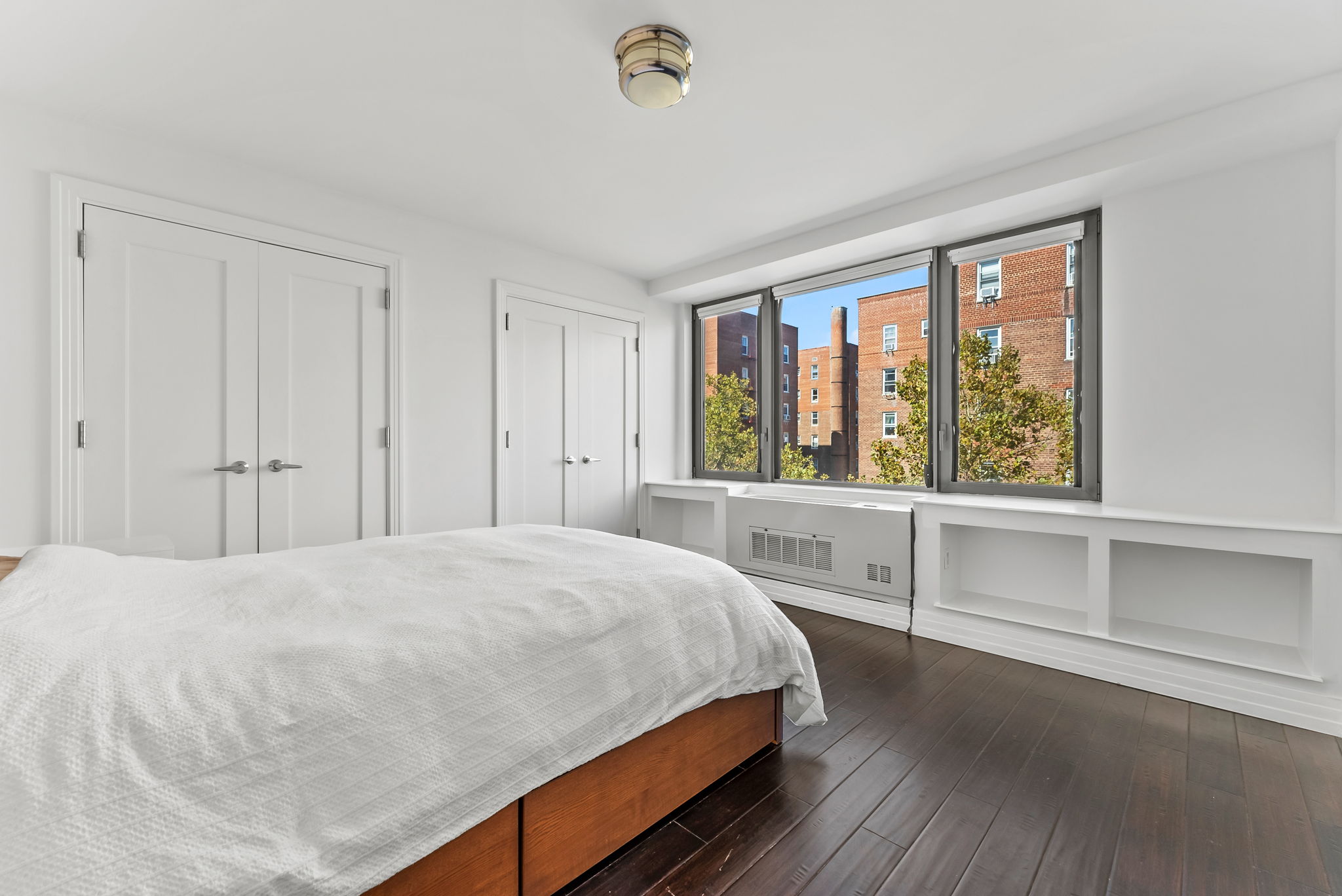 64-05 Yellowstone Boulevard, Unit 414 Queens, NY 11375 - Photo 4 of 14 a bedroom with a bed and a large window