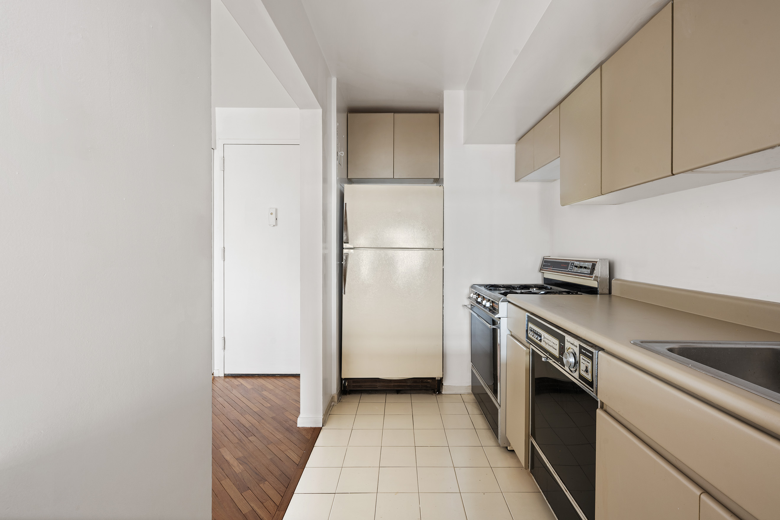 400 East 70th Street, Unit 1903 Manhattan, NY 10021 - Photo 3 of 6 a kitchen with a stove top oven and refrigerator