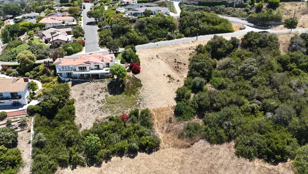 an aerial view of a house with a yard and lake view