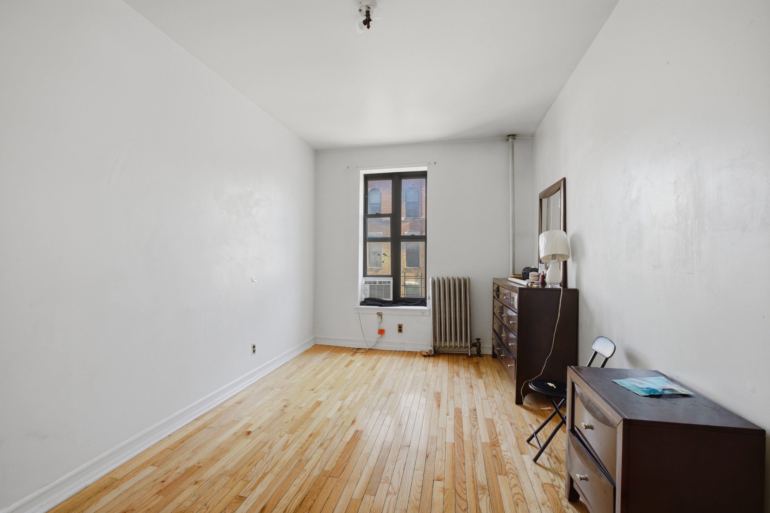 1809 Adam Clayton Powell Jr Boulevard, Unit 2D Manhattan, NY 10026 - Photo 10 of 15 a view of empty room with wooden floor and fan